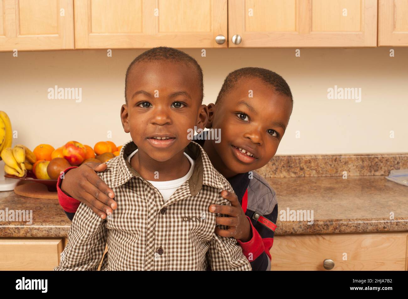 Brothers ages 2 and 4, portrait in kitchen, looking at camera Stock Photo