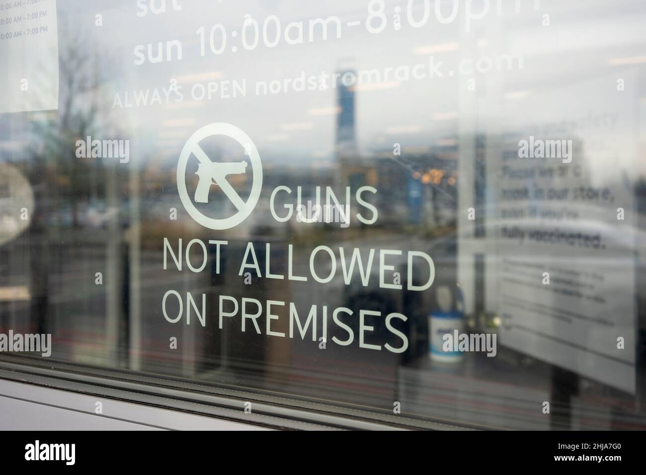 'Guns Not Allowed on Premises' warning sign is seen at the entrance to a Nordstrom Rack store in Portland, Oregon, on Friday, January 14, 2022. Stock Photo