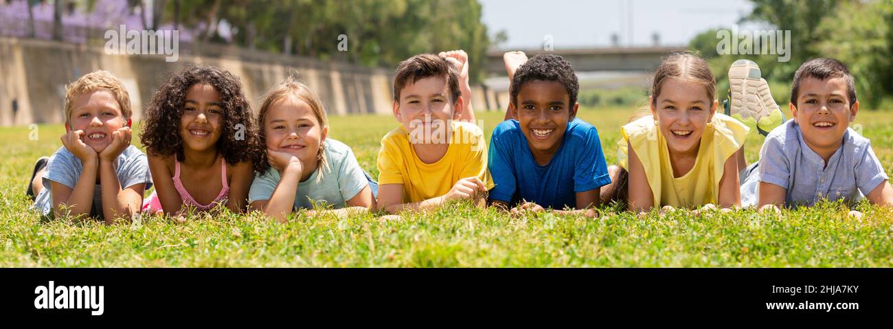 Portrait of smiling children who are posing lying in park Stock Photo ...