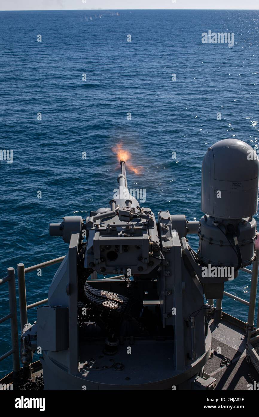 A U.S. Navy MK-38 25mm Bushmaster fires at a floating target during a live-fire training evolution during Composite Training Unit Exercise (COMPTUEX) aboard the USS Kearsarge (LHD 3), Jan. 24, 2022. The 22nd Marine Expeditionary Unit and Amphibious Squadron (PHIBRON) Six are underway for COMPTUEX in preparation for an upcomingdeployment. COMPTUEX is the last at-sea period in the MEU’s Predeployment Training Program; it aims to test the capabilities of the ARG/MEU and achieve deployment certification. (U.S. Marine Corps photo by Sgt. Armando Elizalde) Stock Photo