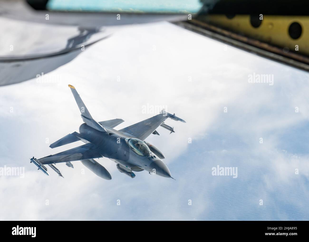 A U.S. Air Force F-16 Fighting Falcon assigned to the 14th Fighter Squadron at Misawa Air Base waits to receive fuel from a 909th Air Refueling Squadron KC-135 Stratotanker during Exercise PACIFIC WEASEL over the Pacific Ocean Jan. 21, 2022. The joint and bilateral exercise directly enhanced U.S. Forces Japan’s ability to detect, deter and potentially defend Japan from adversaries, while empowering service members to be innovative and diversify their approach to any given obstacle. (U.S. Air Force photo by Airman 1st Class Cesar J. Navarro) Stock Photo