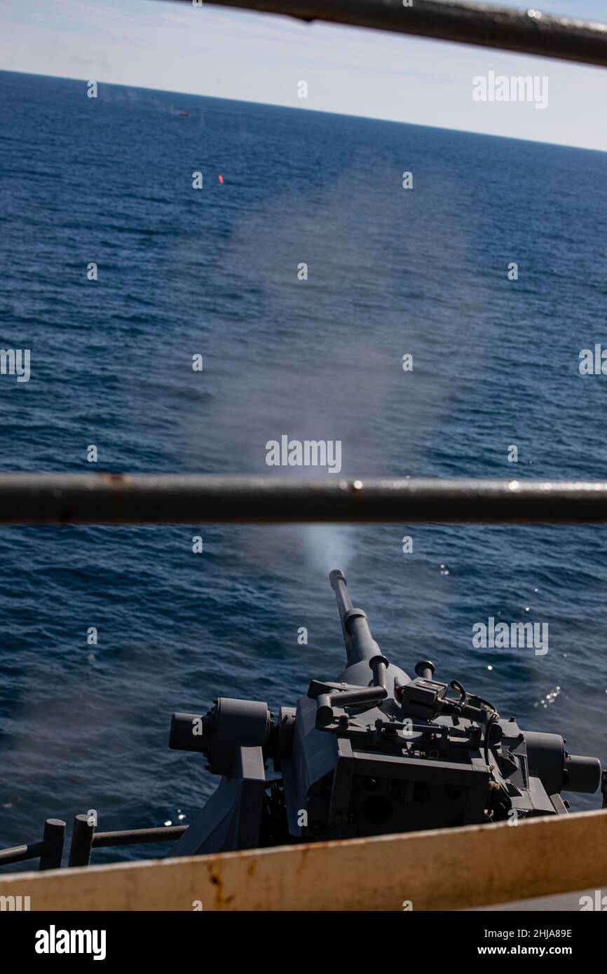 A U.S. Navy MK-38 25mm Bushmaster fires at a floating target during a live-fire training evolution during Composite Training Unit Exercise (COMPTUEX) aboard the USS Kearsarge (LHD 3), Jan. 24, 2022. The 22nd Marine Expeditionary Unit and Amphibious Squadron (PHIBRON) Six are underway for COMPTUEX in preparation for an upcomingdeployment. COMPTUEX is the last at-sea period in the MEU’s Predeployment Training Program; it aims to test the capabilities of the ARG/MEU and achieve deployment certification. (U.S. Marine Corps photo by Sgt. Armando Elizalde) Stock Photo