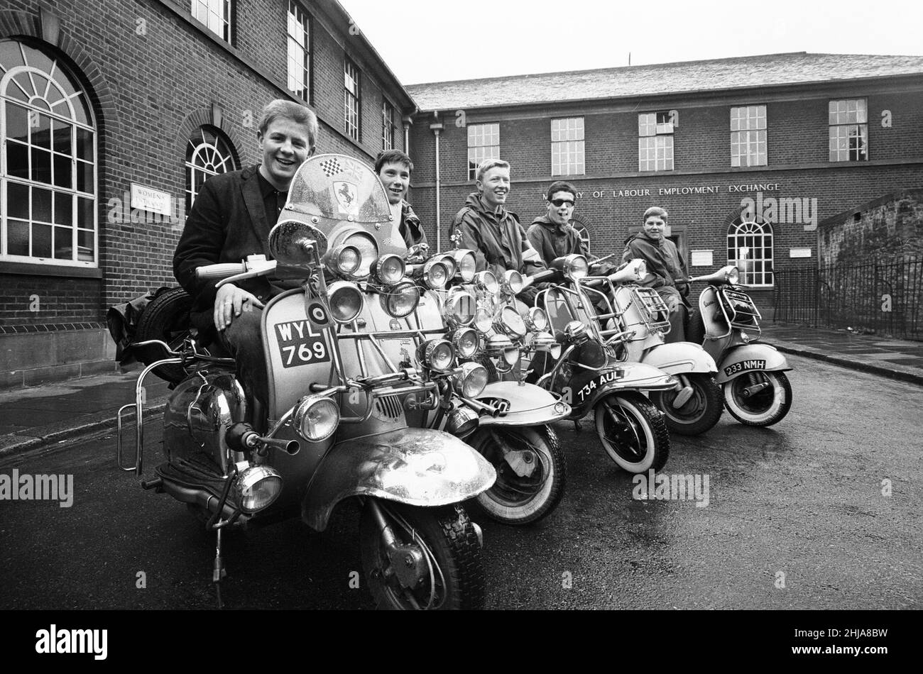 The mods and rockers were two conflicting British youth subcultures of the early to mid-1960s. Media coverage of mods and rockers fighting in 1964 sparked a moral panic about British youths, and the two groups became labelled as folk devils. John Rogers on his scooter with friends in peckham. 6th May 1964. Stock Photo
