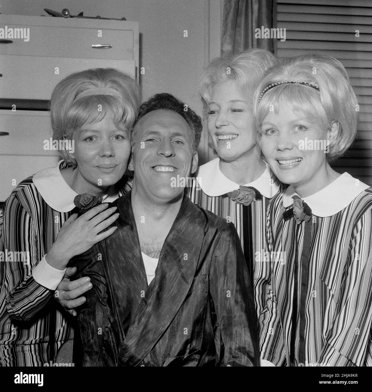 Bruce Forsyth with The Beverly Sisters. Picture taken at The Talk of the Town, London, where Bruce was having his opening night.  The Beverley Sisters are captioned left to right here as Babs, Joy and Teddie. They are a British female vocal and light entertainment trio, most popular during the 1950s and 1960s. Eldest sister Joy and the twins, Teddie and Babs, loosely modelled on that of their American counterparts, the Andrews Sisters.  Picture taken 5th May 1964   Bruce Forsyth with The Beverly Sisters.  Picture taken at The Talk of the Town, London, where Bruce was having his opening night. Stock Photo
