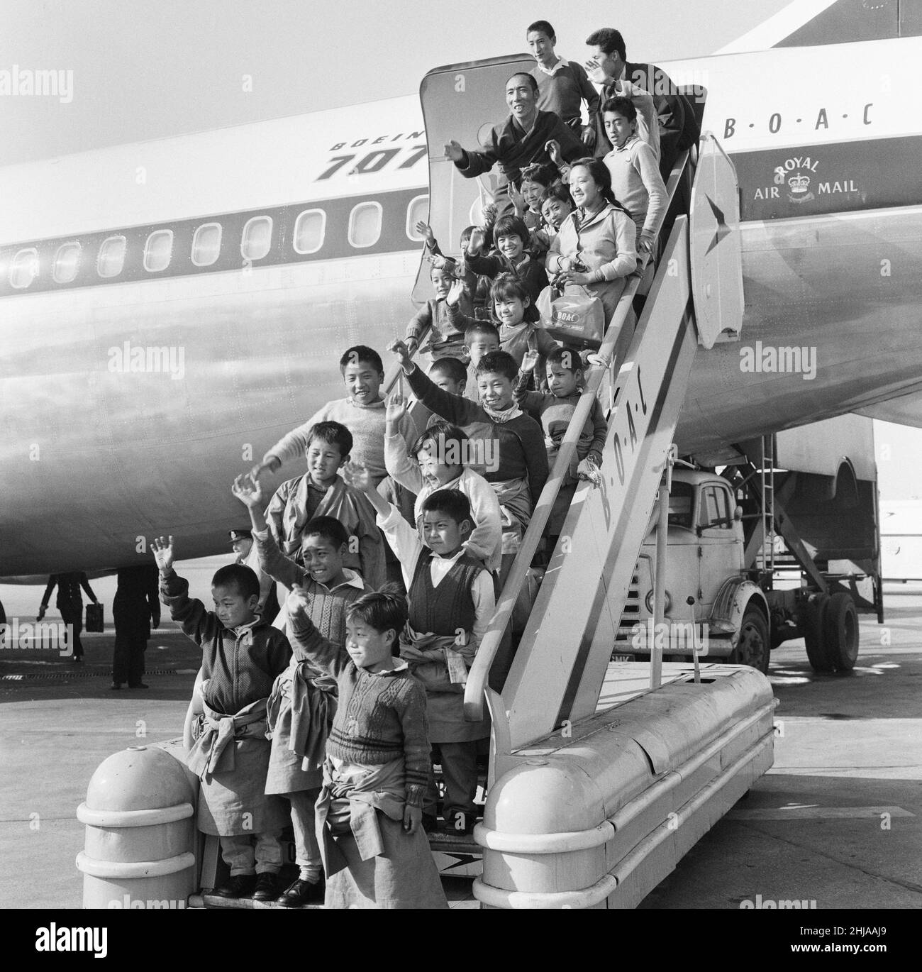 21 Tibetan Refugee Children land at London Heathrow Airport, Tuesday 26th February 1963. A BOAC Airliner brings the thirteen boys and eight girls to the UK, from a refugee camp in northern India. Many now orphaned, the children have fled chinese occupation and persecution.   Our Picture Show ... tibetan refugees pose for photographs as they leave aircraft.   The children are to be relocated to the Pestalozzi Village for Children in Sedlescombe, East Sussex, which will be their new home for the next ten years.   The community is named after eighteenth century Swiss educationalist, Johann Heinri Stock Photo