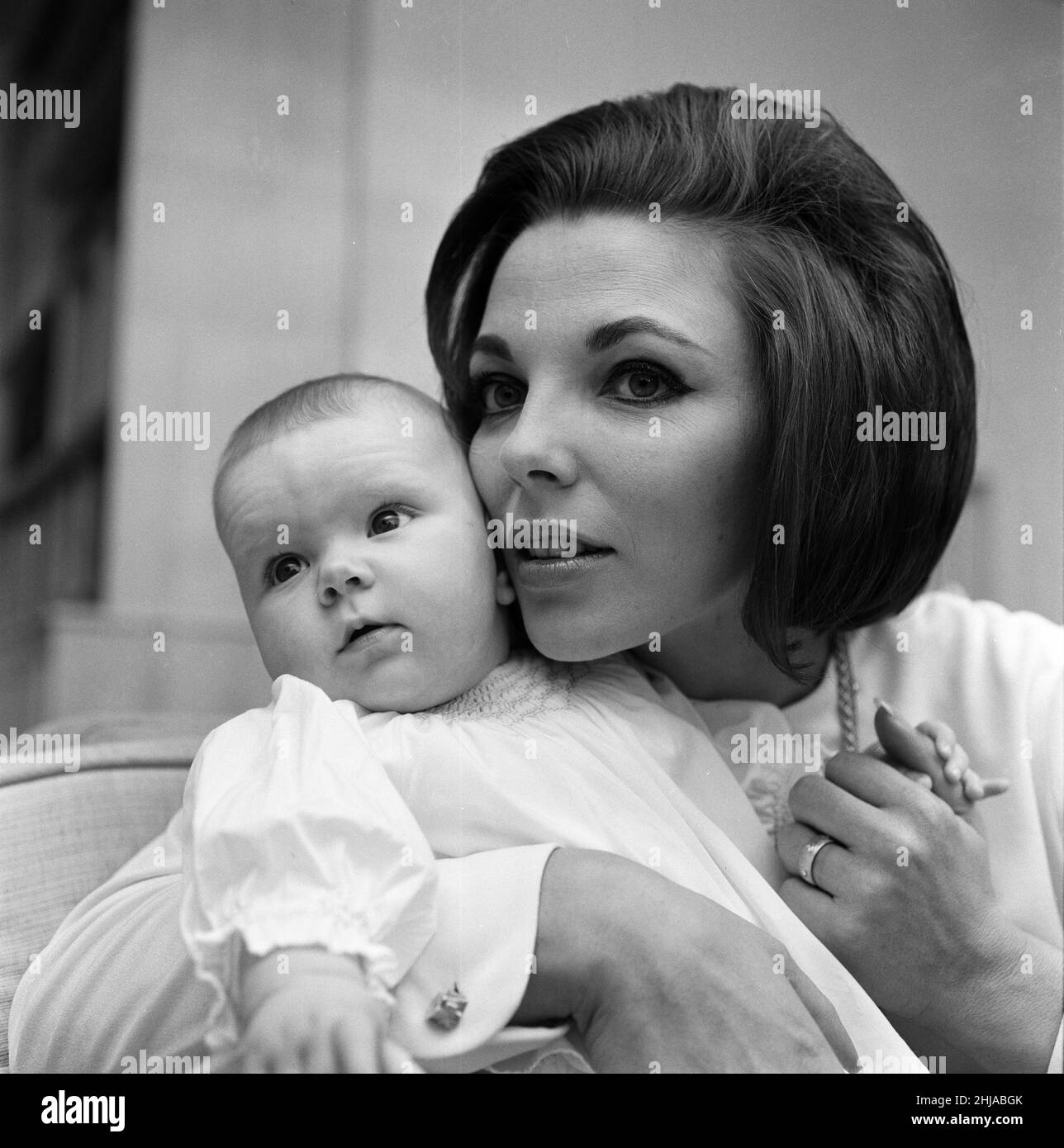 Joan Collins pictured with her four-month-old daughter Tara Newley. They have come home to London to see the family. Here they are today after mum has been in the film studios and baby Tara woke after her sleep. 20th February 1964. Stock Photo