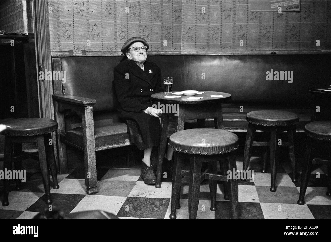 91-year-old Harriet Brookes has been elected the most loyal drinker of Ansell's Beer. As a reward she is able to receive a free pint of beer a week and has her own seat reserved in her local - The Prince George, Crabtree Road, Birmingham. 25th February 1964. Stock Photo