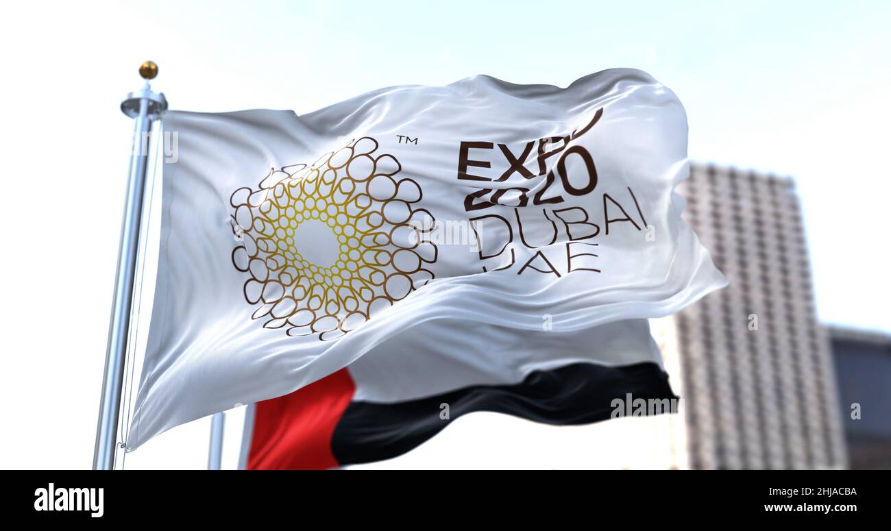 Dubai, UAE, January 2022: the flag of Expo 2020 waving in the wind with the UAE flag blurred in the background. Stock Photo