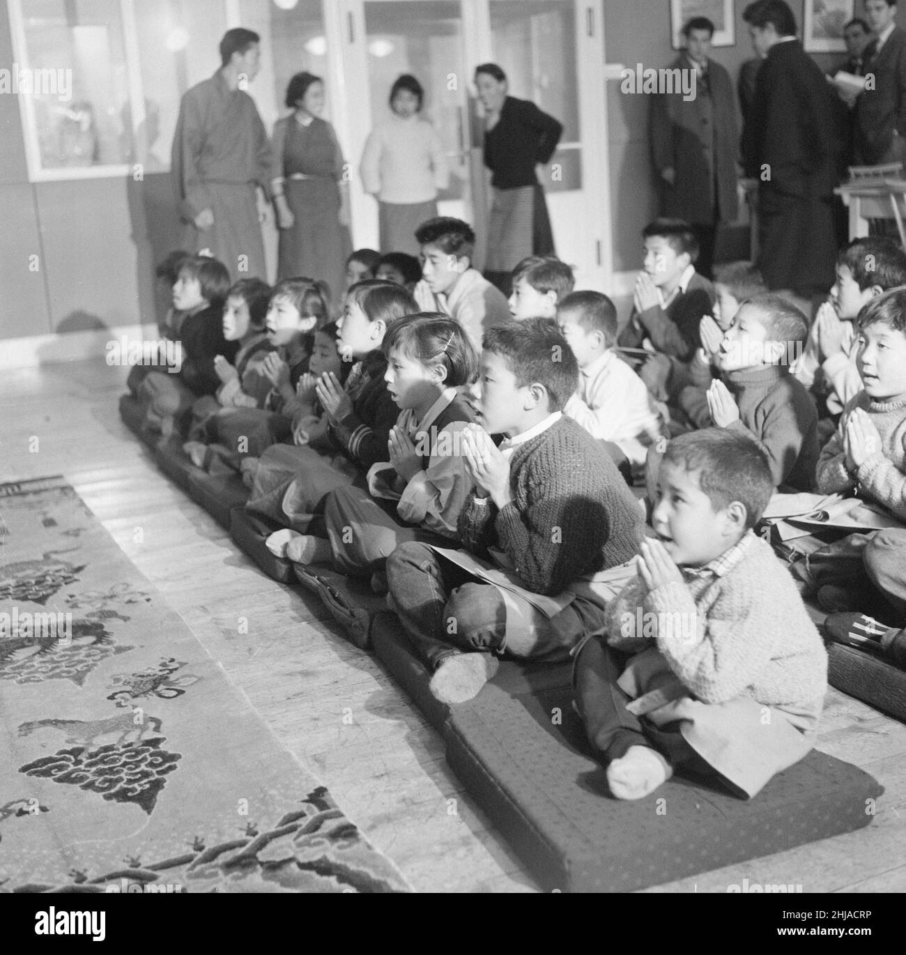 Tibetan Refugee Children at Pestalozzi Village for Children in Sedlescombe, East Sussex, 7th March 1963. Our Picture Shows ... Children participate in Buddhist prayers twice a day.   The thirteen boys and eight girls arrived in the UK, from a refugee camp in northern India. Many now orphaned, the children have fled chinese occupation and persecution.   The community is named after eighteenth century Swiss educationalist, Johann Heinrich Pestalozzi, who devoted his life to closing divisions in society through education of the whole person, their Head, Heart and Hands. Stock Photo
