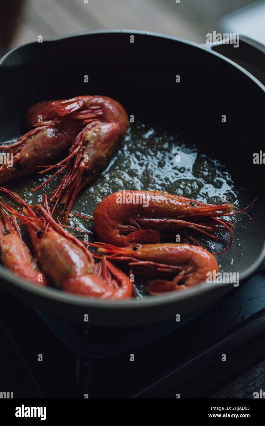 heating spot prawns with garlic butter in pan Stock Photo