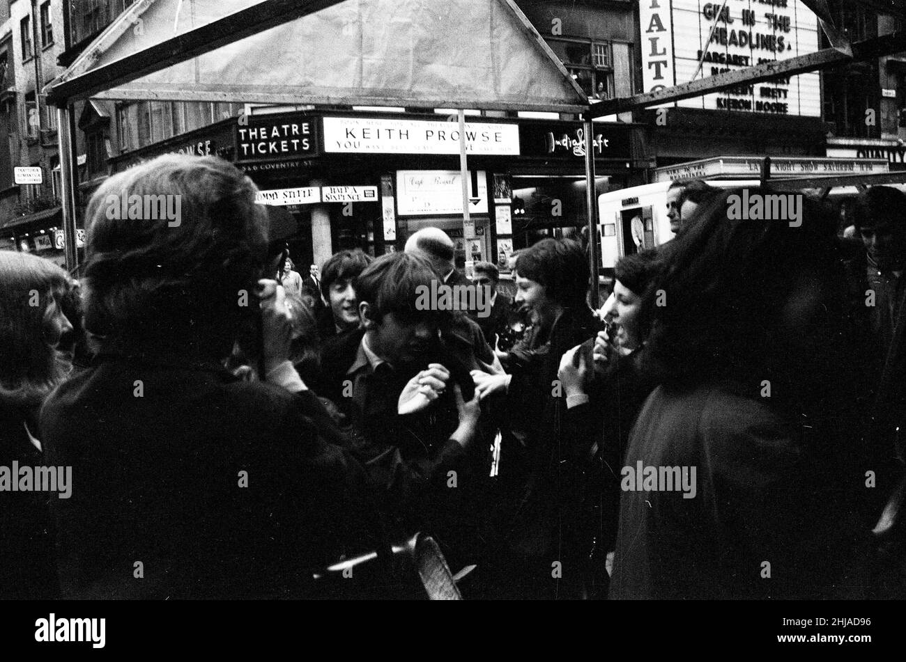 Scenes at The Prince of Wales Theatre in London when The Beatles arrived at the front entrance today for rehearsals of the Royal Variety Command Performance. Picture shows Ringo Starr, and behind him, John Lennon, arriving at the theatre.  Picture taken 4th November 1963 Stock Photo