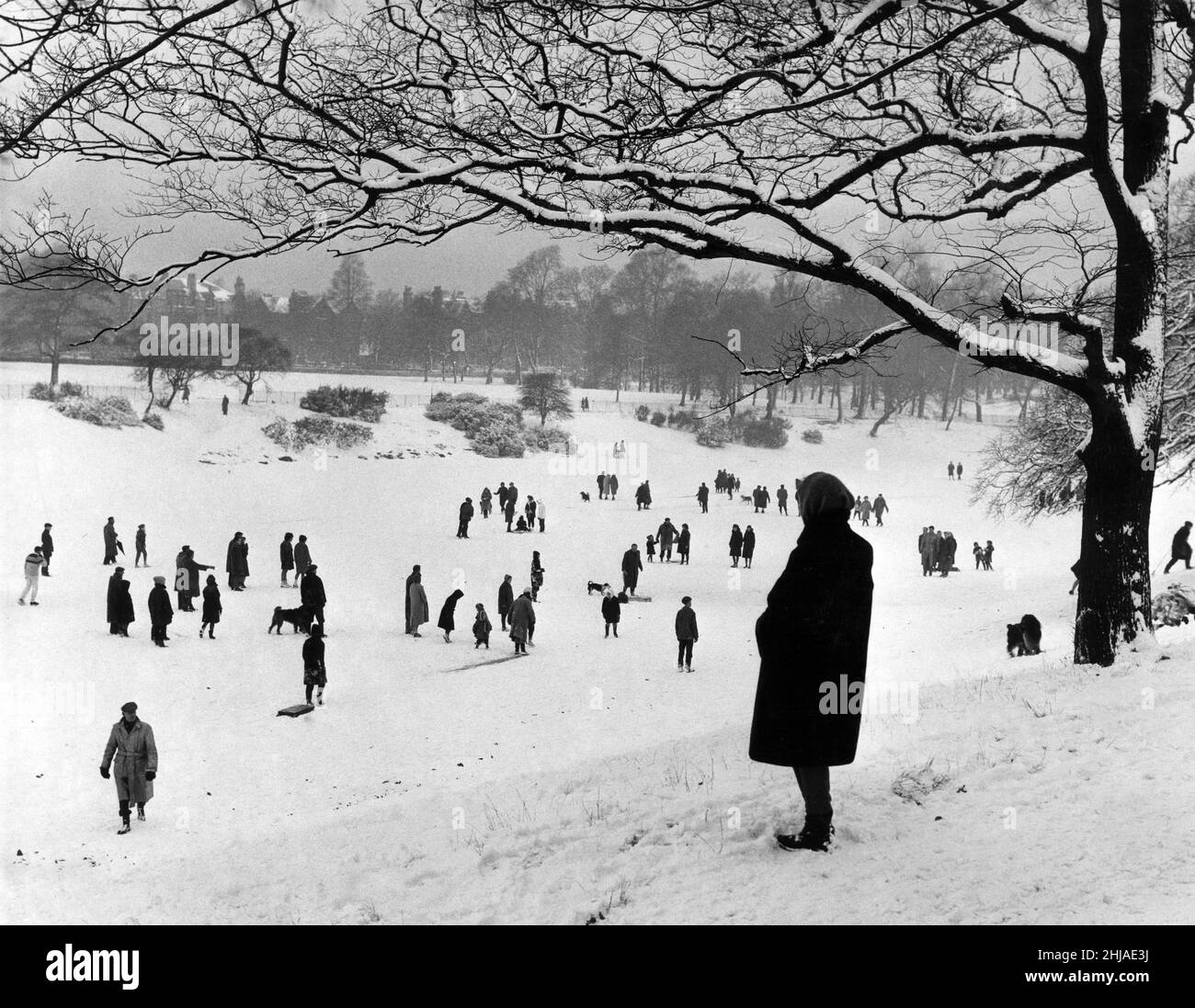 An afternoon walk on the park lake. The overnight fall of snow ruined skating chances on Sefton Park lake but many people had the experience of walking on the lake. The Parks Department allowed this for the first time in 15 years. Liverpool, Merseyside. 21st January 1963. Stock Photo