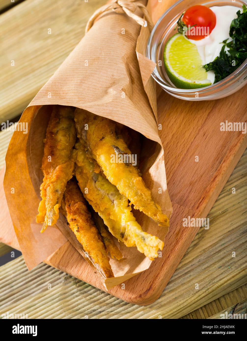 Fried in batter anchovies with creamy cheese sauce and greens Stock