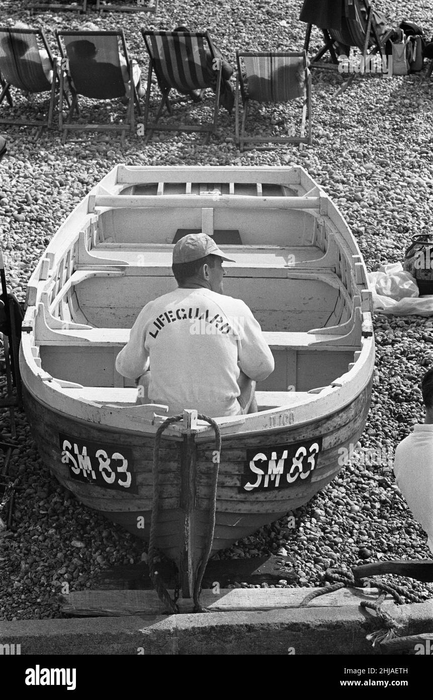 Holiday scenes at Brighton .Lifeguard sitting in a rowing boat on Brighton beach. 7th July 1963 Stock Photo