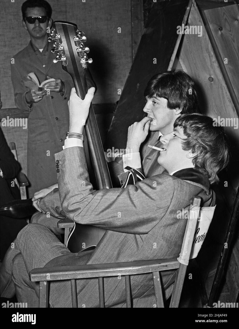 The Beatles pose for pictures during filming of A Hard Day's Night at Madame Tussauds in London.(Picture shows) Ringo Starr and Paul McCartney posing with a guitar. 12th March 1964. Stock Photo