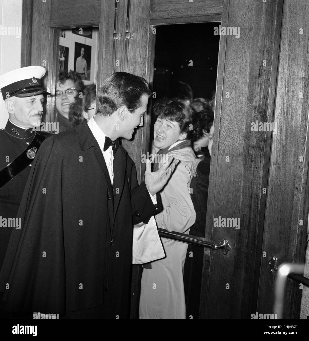 The world premier of  'The Main Attraction' at the Plaza, Piccadilly, which stars Pat Boone and Nancy Kwan. Pictured, Pat Boone waving to fans through the door of the theatre. 25th October 1962. Stock Photo