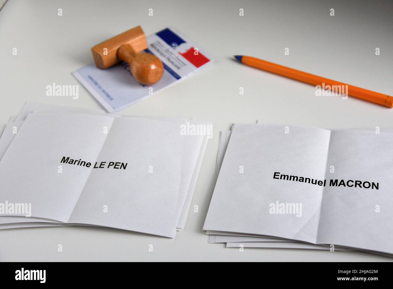 In this photo illustration, ballot papers of Marine Le Pen and Emmanuel Macron are seen displayed on a table with a voters card, a stamp and a pen. Despite not officially being a candidate for re-election, the President of the French Republic, Emmanuel Macron is leading the polls for the presidential elections of 2022 with 25% of the voting intentions, putting him ahead of Marine Le Pen of the Rassemblement National (RN or National Rally) party, who polled only 17%. The first round of France's Presidential election will take place on April 10, 2022. Stock Photo
