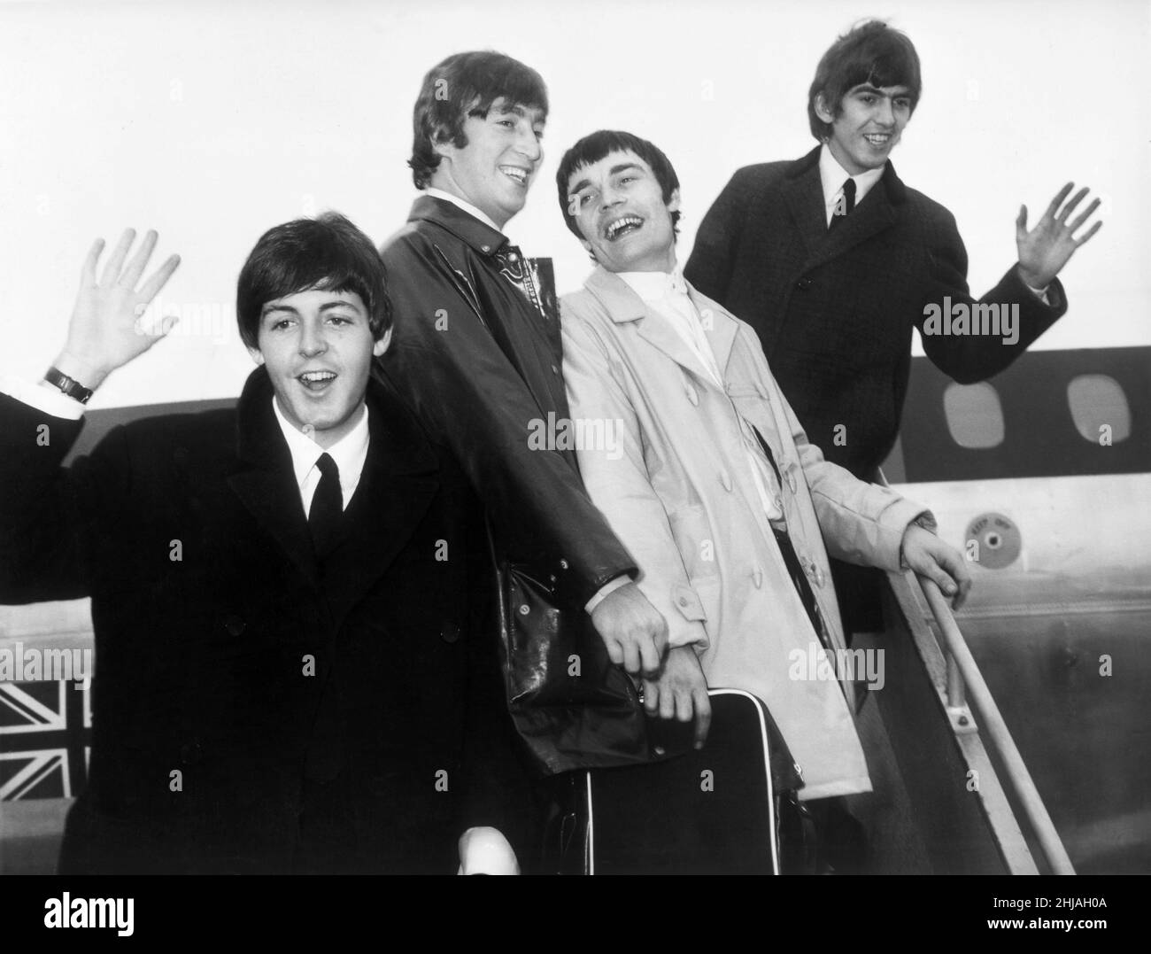 The Beatles at London Airport at the start of their European Tour 4th June 1964.They will be in concert later this evening at the Tivoli Gardens, Copenhague, Denmark.   Picture shows left Paul McCartney, 2nd left John Lennon, 2nd right in white coat  is stand in drummer Jimmie Nicol and far right George Harrison.  Jimmie Nicol was an urgently organised stand in drummer for Ringo Starr, when Ringo became ill with Tonsillitis on the eve of a tour. Jimmy performed 8 shows with The Beatles throughout Europe and Australia during June 1964.  Picture taken 4th June 1964 Stock Photo