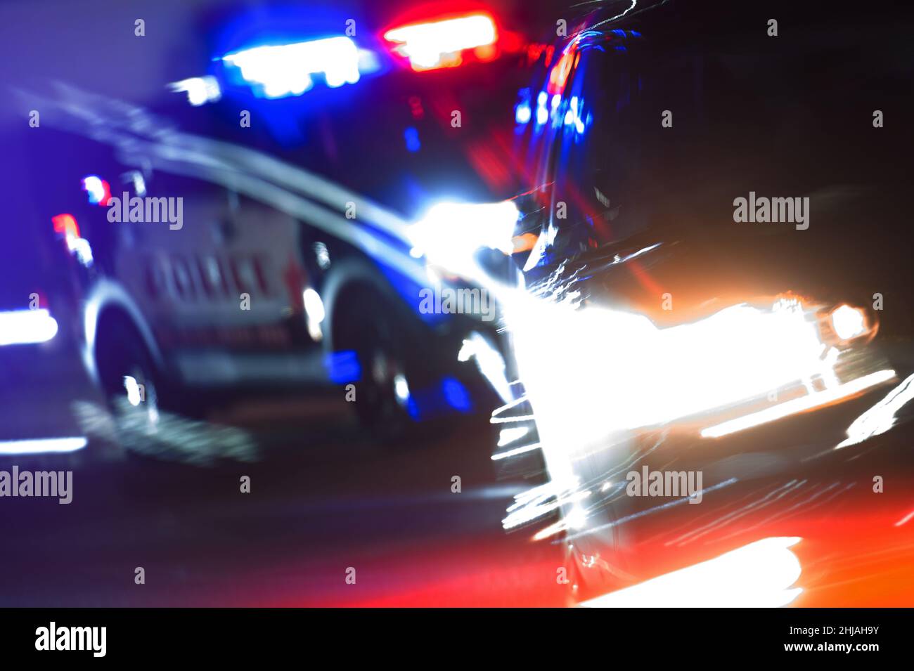 Hot Pursuit Police Traffic Chase at Night. Police Cruiser Next to Running Out DUI Driver Conceptual Photo with Motion Blurs. Police Enforcement Theme. Stock Photo