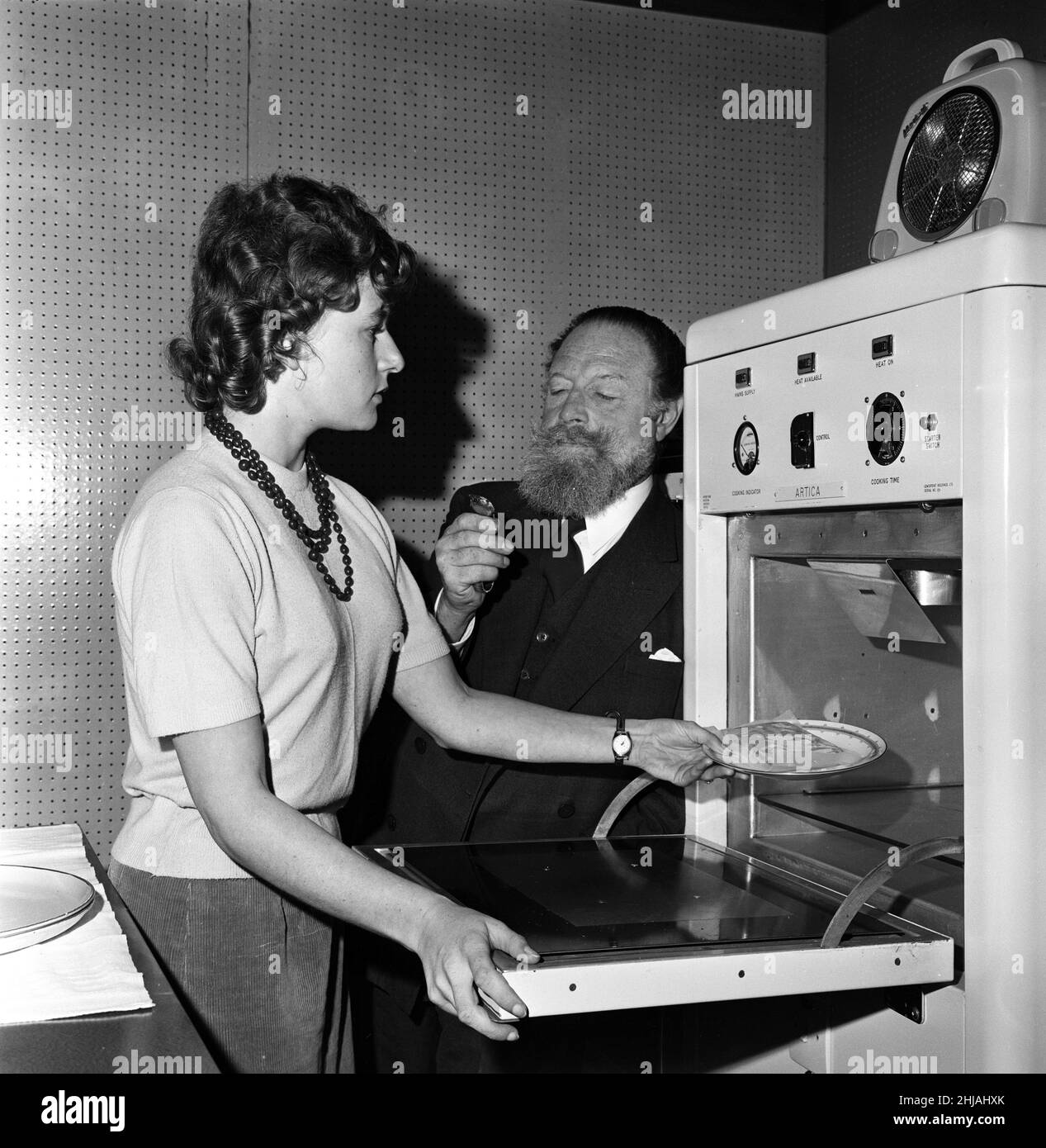 Cooking by microwaves. Circa 1962. Stock Photo