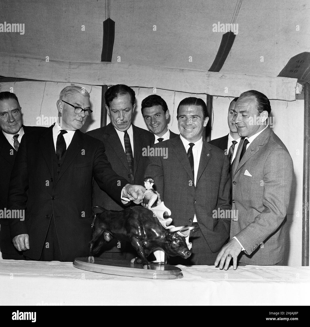 Real Madrid football players after the presentation of a magnificent matador and bull in Royal Doulton pottery that was presented to the President of Real Madrid. Mr Frank Kerry (left) the export manager for the firm that made the Matador and Bull shows the finer points of the figure to Mr Henshall a director of Stoke. 26th April 1963. Stock Photo