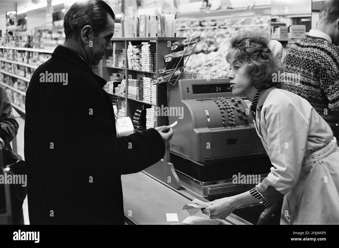 Shoppers, Fine Fare Supermarket, Wilton, London, 29th October 1963. Collect Green Shield Stamps at till after paying for goods. Green Shield Stamps is a British sales promotion scheme that rewards shoppers with stamps that could be redeemed, and used to buy gifts from a catalogue or from any affiliated retailer. Stock Photo