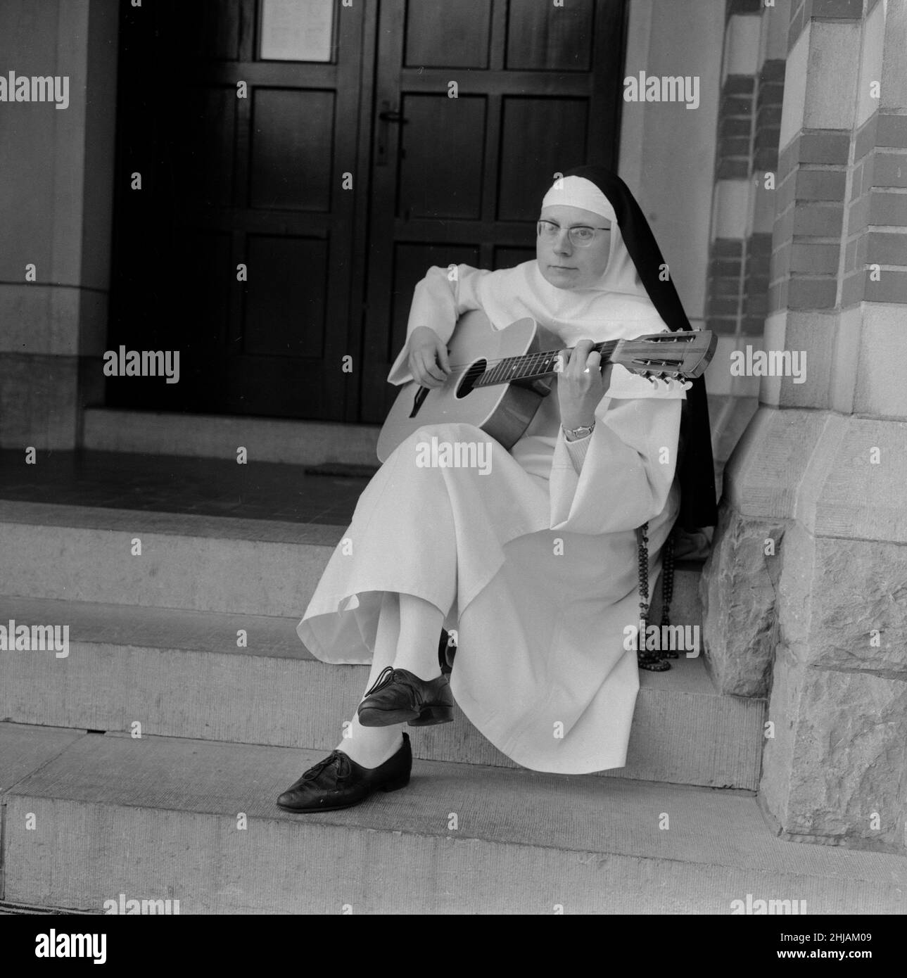 The Singing Nun, born Jeanne-Paule Marie Deckers, she is a nun at the Dominican Fichermont Convent in Fichermont, Belgium.   Pictured on steps of convent December 1963    A.k.a.  Sister Luc Dominique  Sister Sourine  Jeanine Deckers  Soeur Sourire   Sister Smile Stock Photo