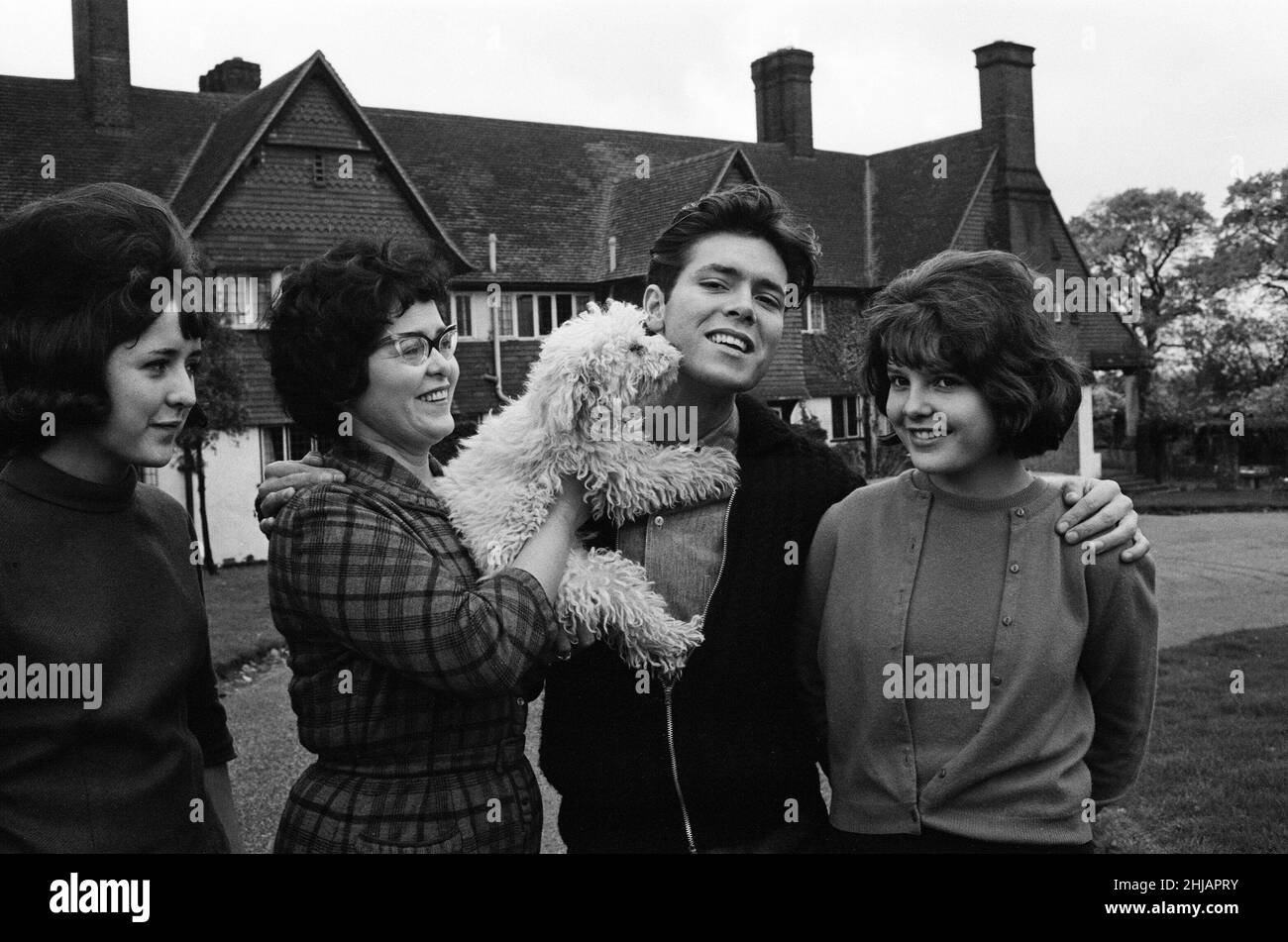 Cliff Richard at his tudor style mansion at Upper Nazeing, Essex. He will live there with his mother and two sisters Jackie 16 and Joan 13. It has six bedrooms, a garage for five cars and is set in eleven acres of ground, the price was ¿30,000. Cliff with his mother Mrs Dorothy Webb (wearing glasses), and sisters Jackie (check skirt) and Joan. 10th November 1963. Stock Photo
