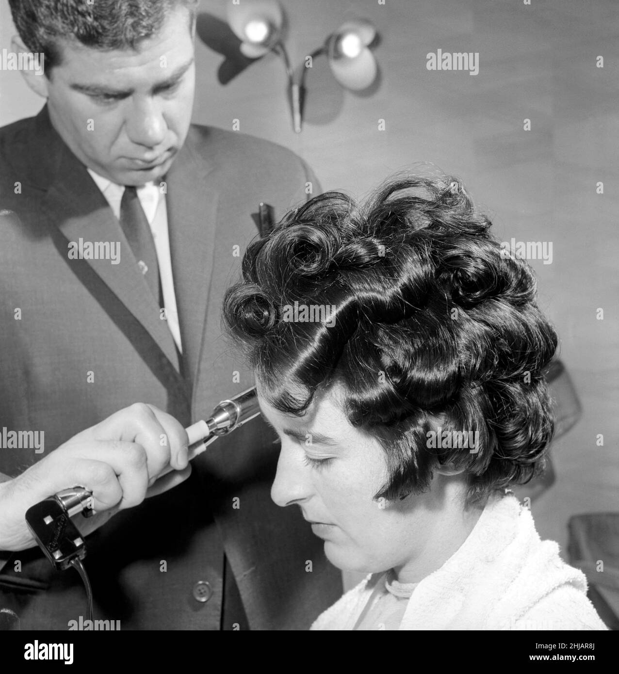 Woman have her hair cut and curled at the hair dressers 7th june 1962