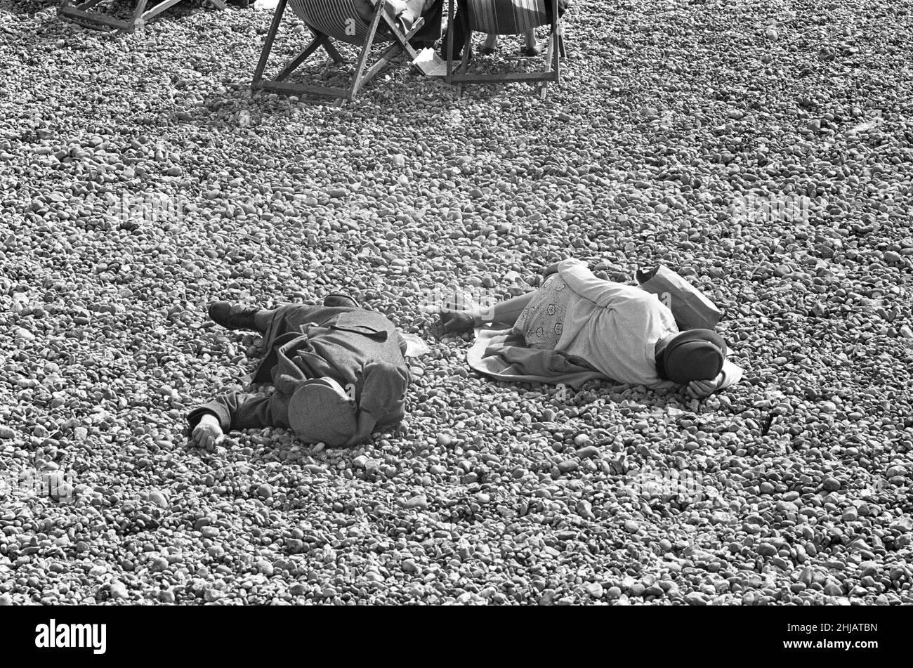 Holiday scenes at Brighton .Two elderly holidaymakers sleeping on the beach after walking the promenade. 7th July 1963 Stock Photo