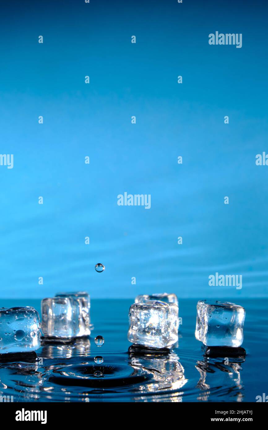 Ice cubes in bright blue water and a splash of raindrops Stock Photo ...