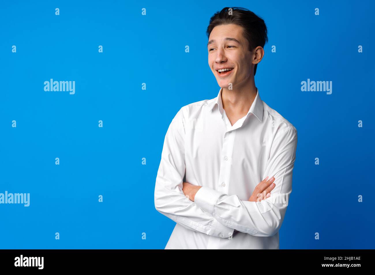 Portrait of a smiling teen boy against blue background Stock Photo - Alamy