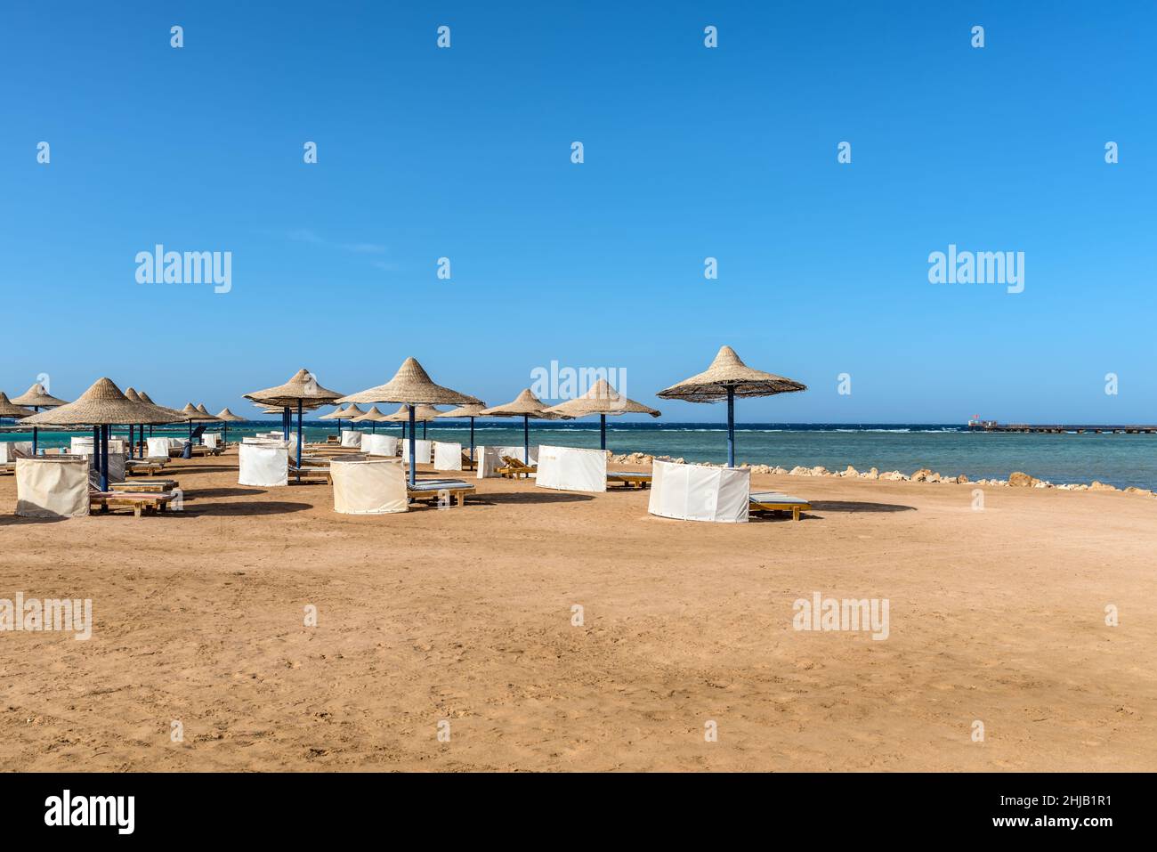 Hurghada, Egypt - June 03, 2021: Umbrellas and sun loungers on an empty beach of the Labranda Club Hotel located in Makadi Bay, which one of Egypt bea Stock Photo