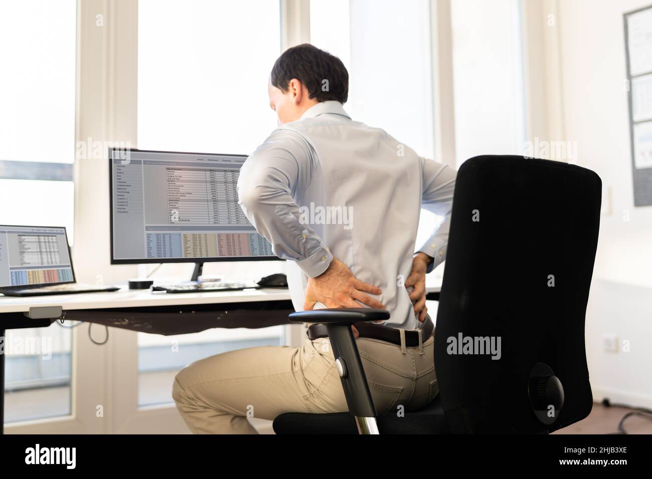 Back Pain Bad Posture Man Sitting In Office Stock Photo Alamy