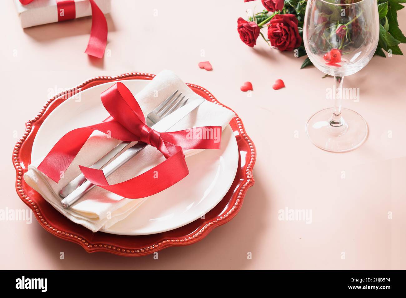 Valentines day table setting with red decoration, gift and roses on ...