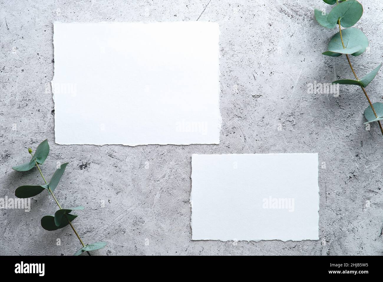 Wedding RSVP cards templates with eucalyptus on stone table top view. Stock Photo
