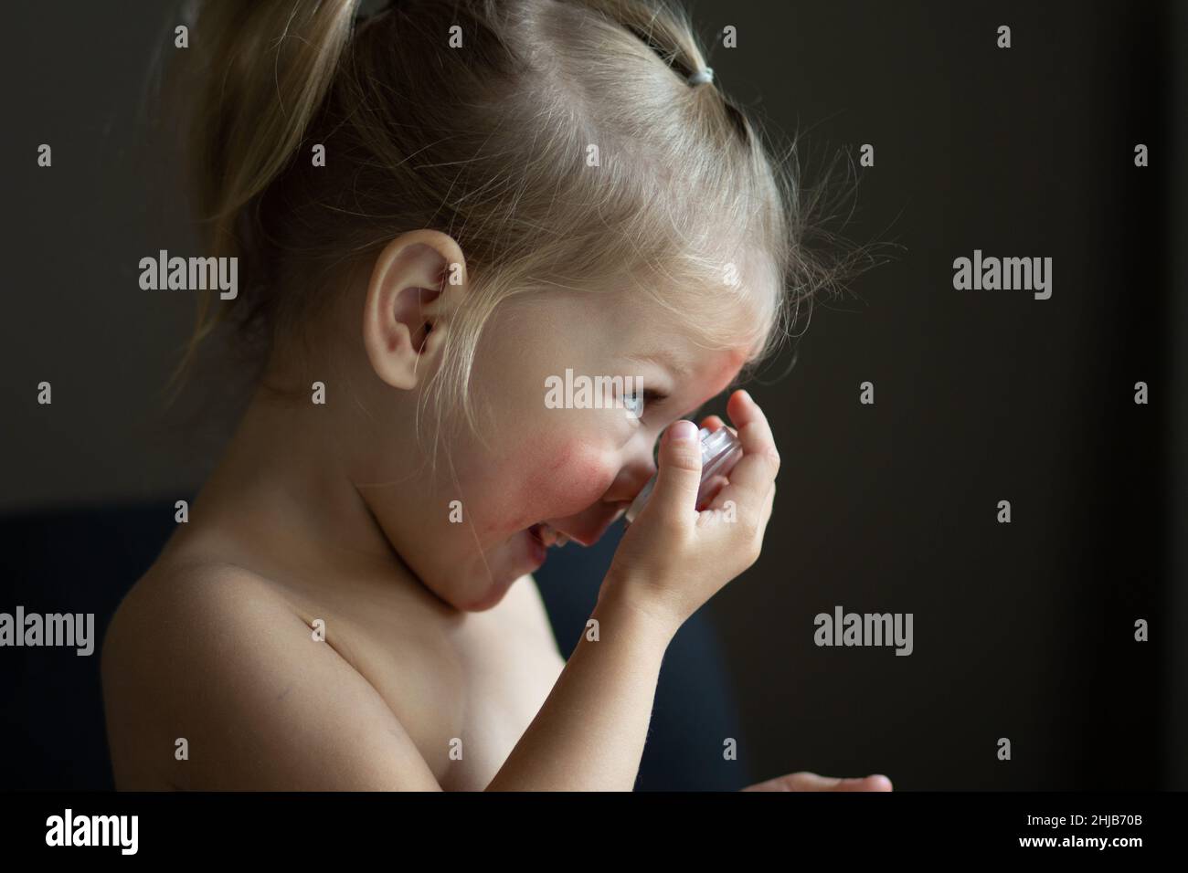 Child applying rouge making up on her face Stock Photo - Alamy
