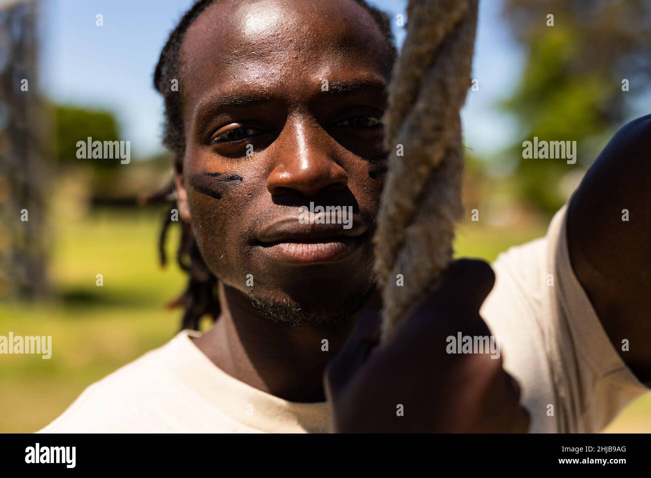 Portrait of african american male soldier holding a rope at boot camp Stock Photo