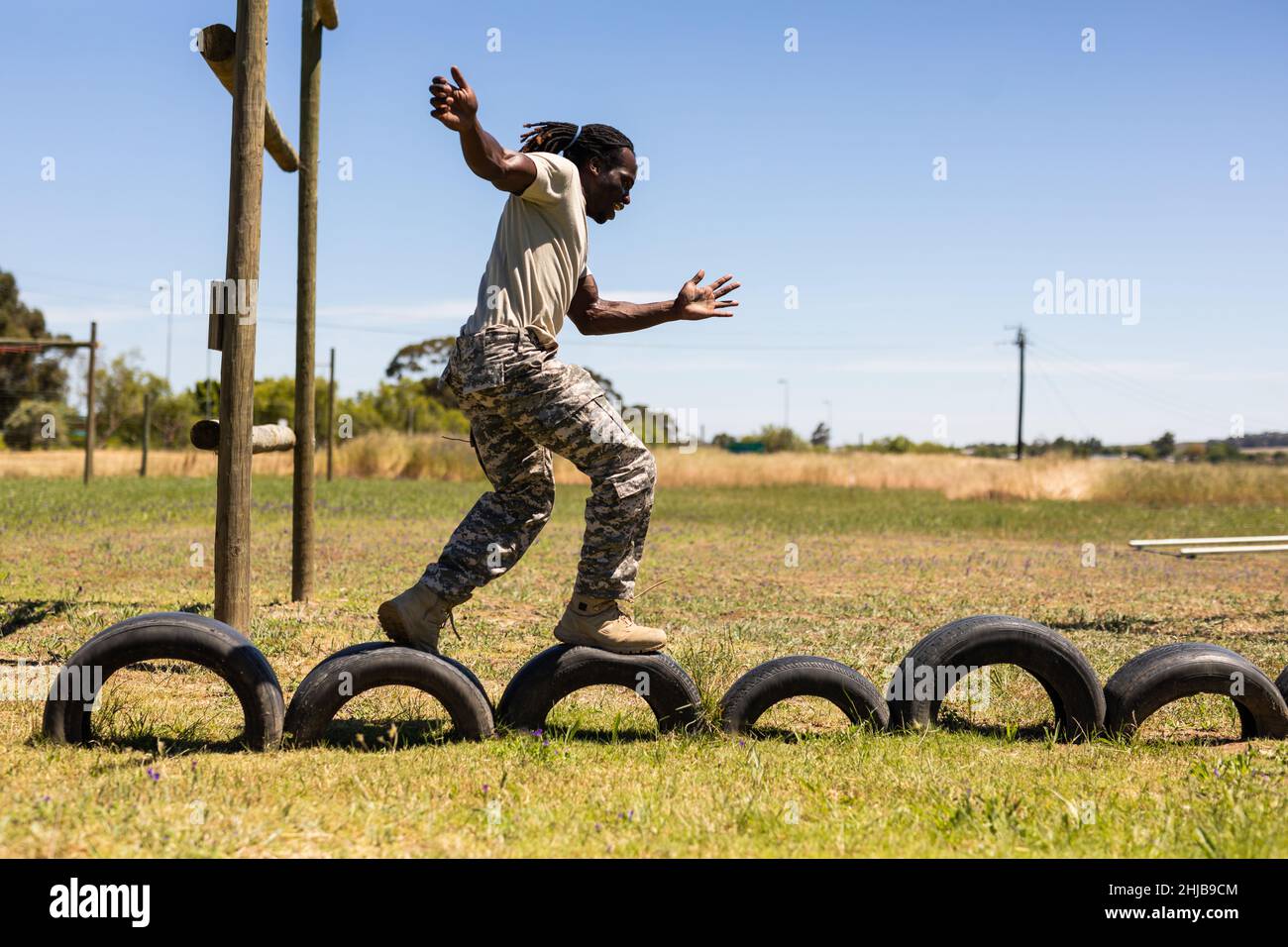 African american male soldier walking on tires during obstacle course at boot camp Stock Photo
