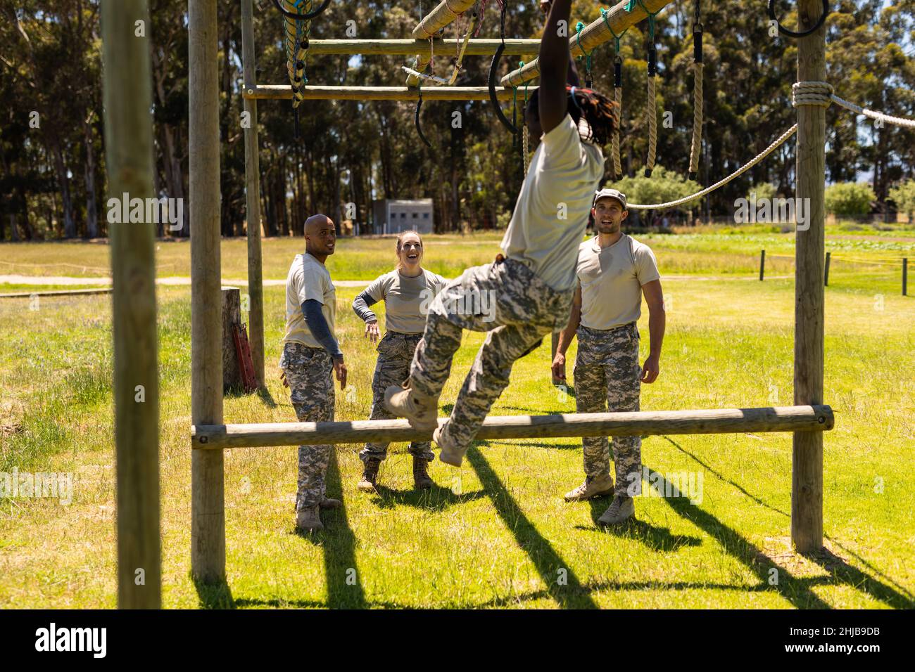 African american soldier climbing monkey bars during obstacle course at boot camp Stock Photo