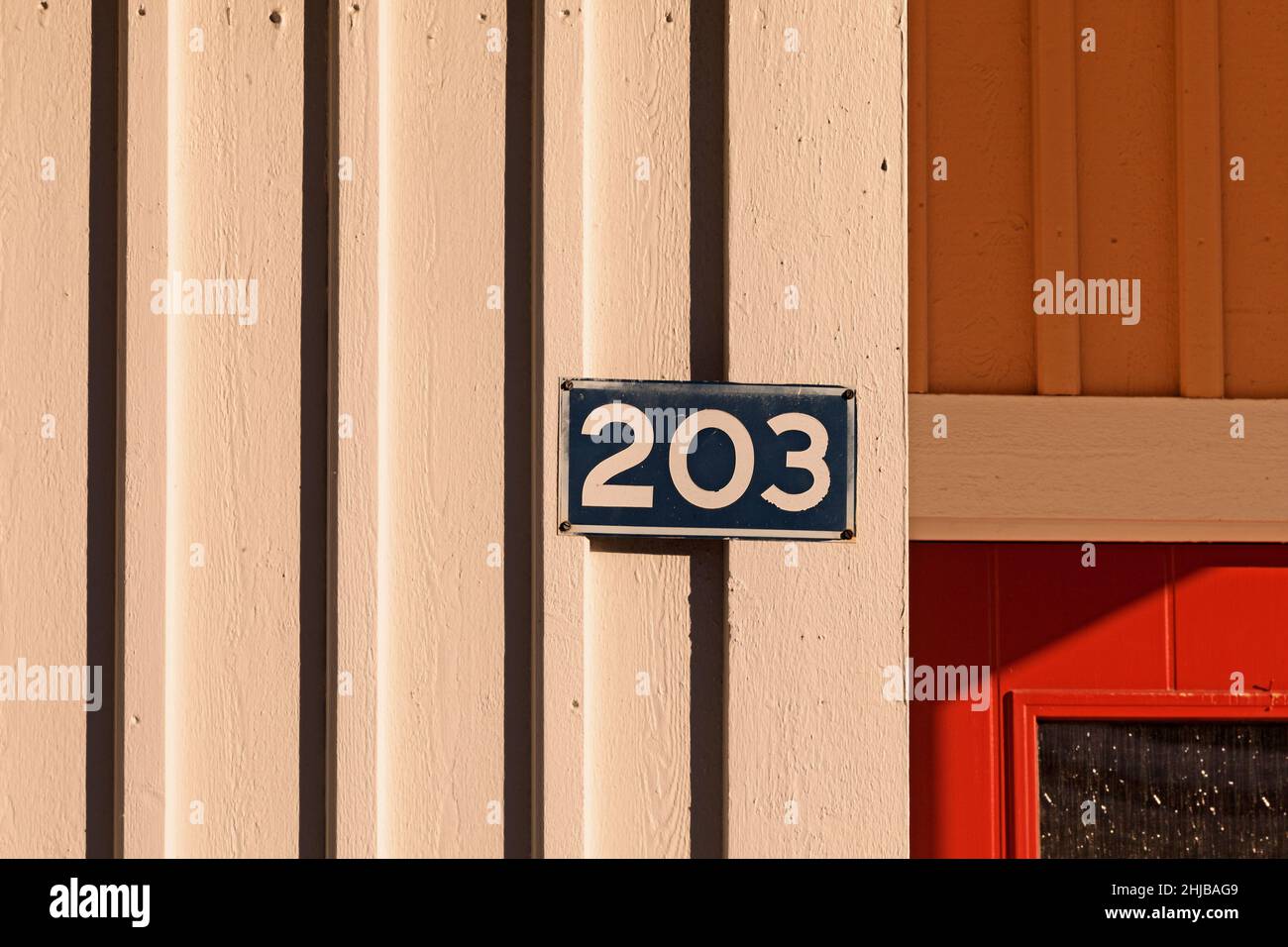 number 203 on a sign and wood on which the spring light falls differently Stock Photo