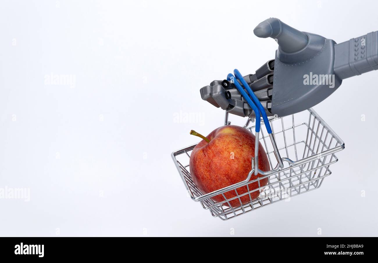 robot hand holds a grocery basket with an apple. food delivery using