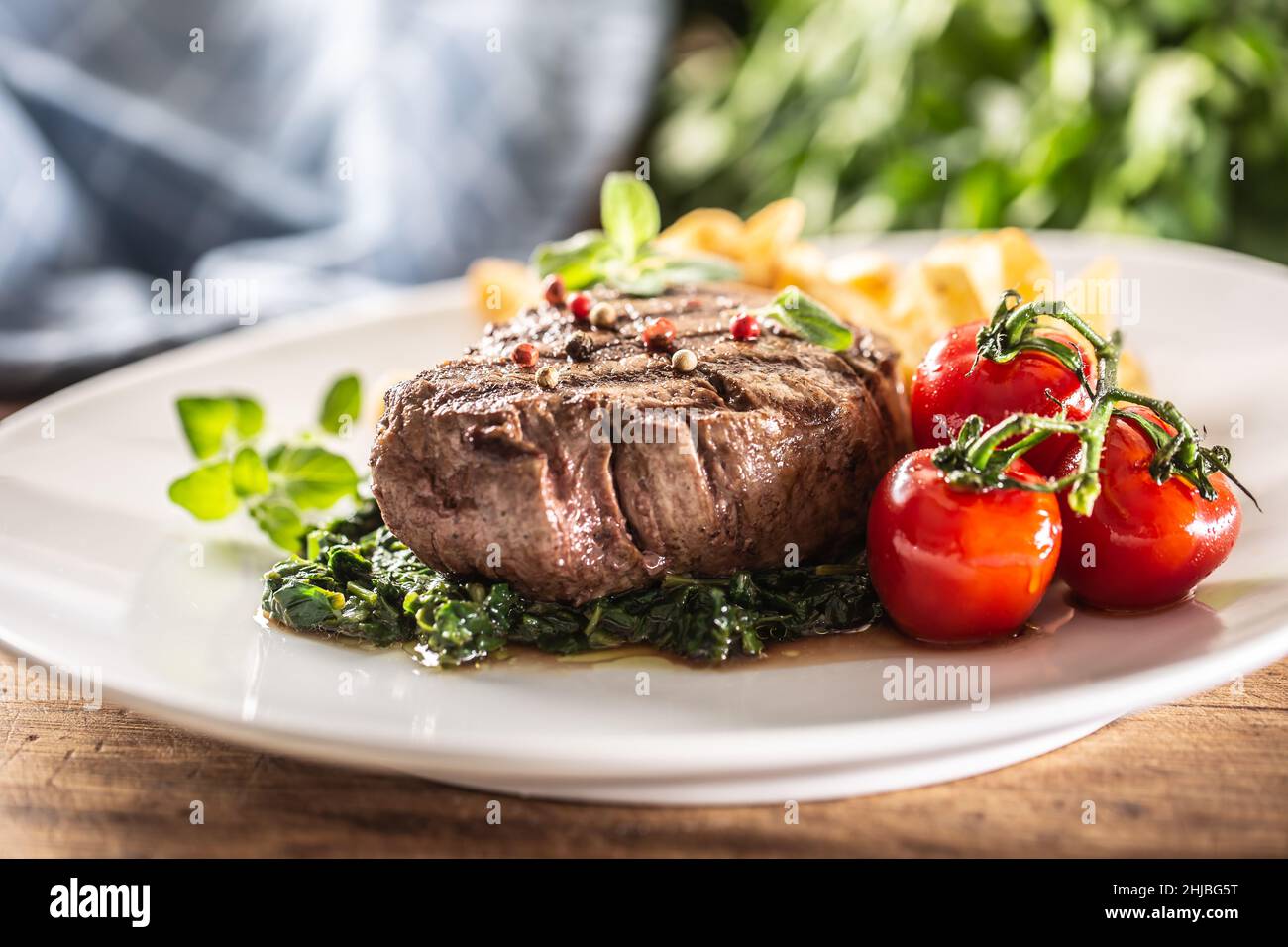 Welldone steak served with veggies on a plate ready to be eaten Stock