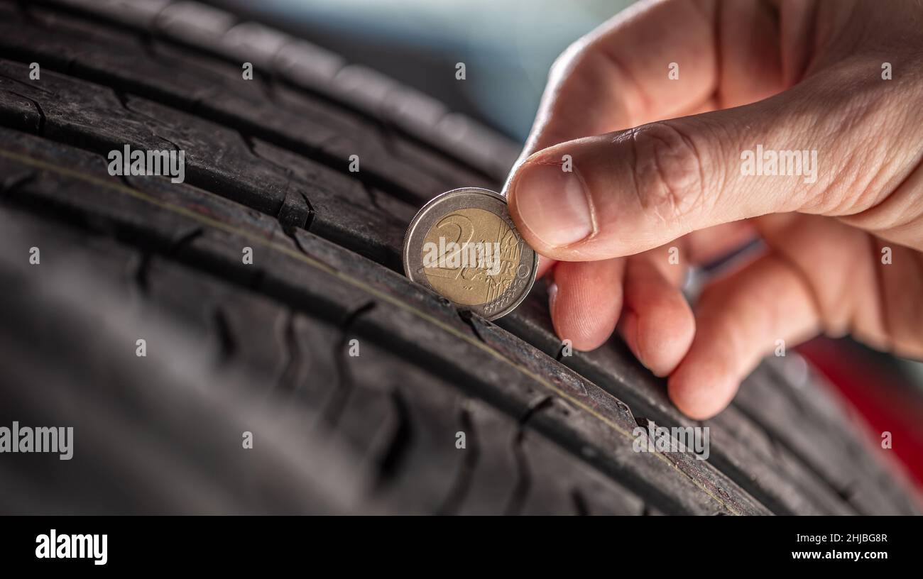 Tire tread measuring by a two euro coin placed into the pattern of the