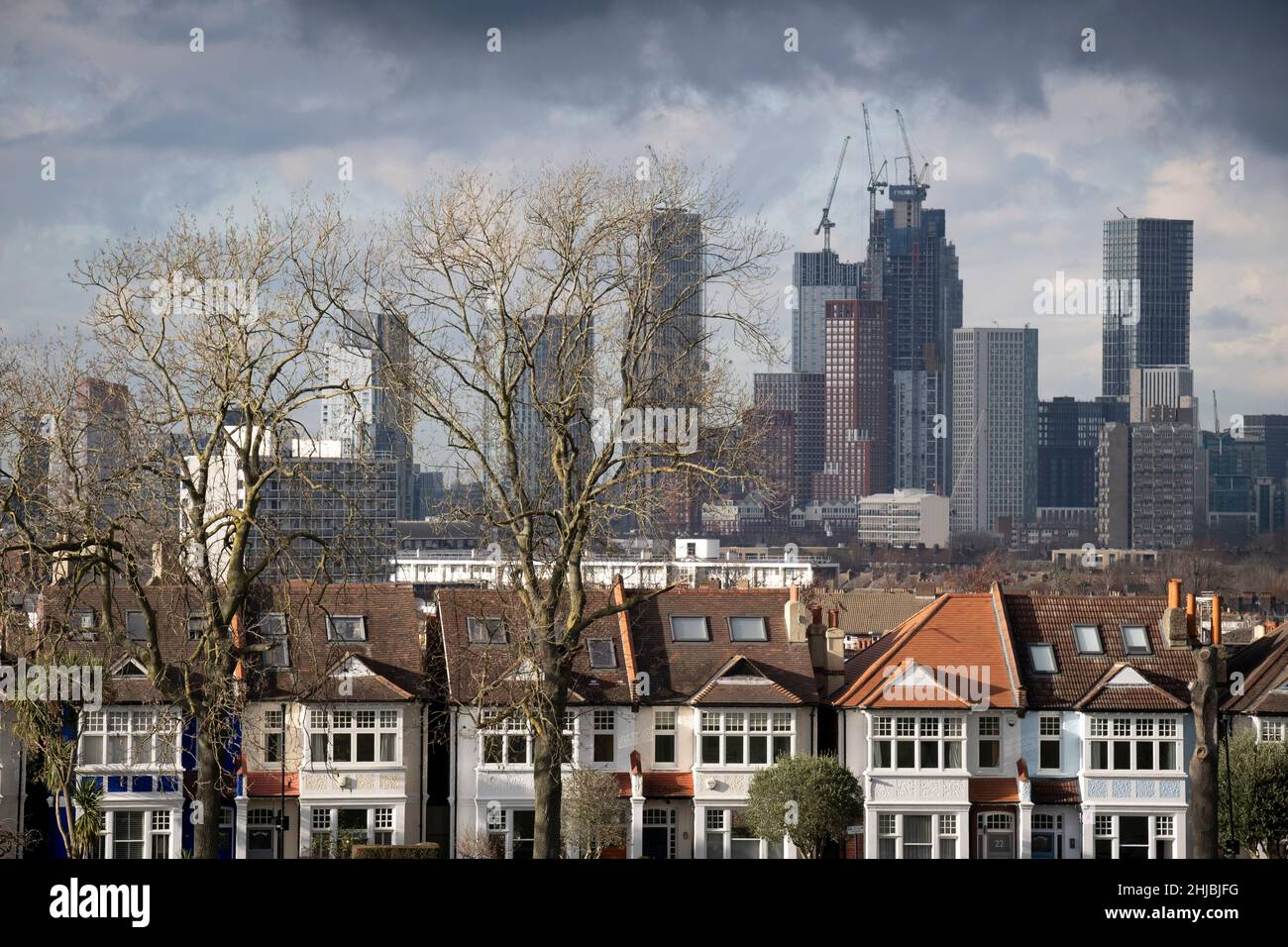 Residential high-rise towers in the distance at Nine Elms and period homes on one side of Ruskin Park in Lambeth, on 27th June 2022, in London, England. Stock Photo