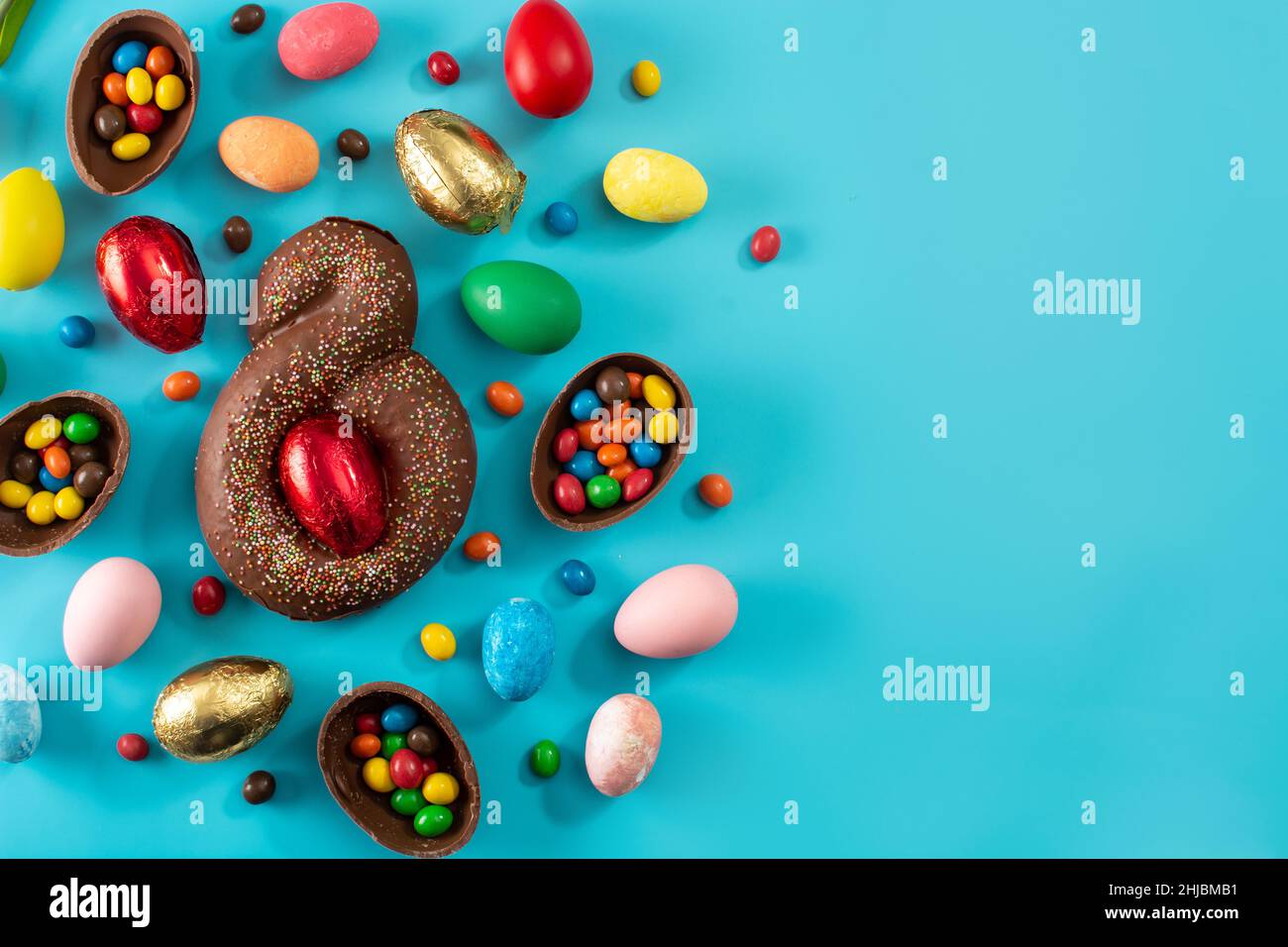 Mona de pascua cake and Easter eggs on blue background Stock Photo