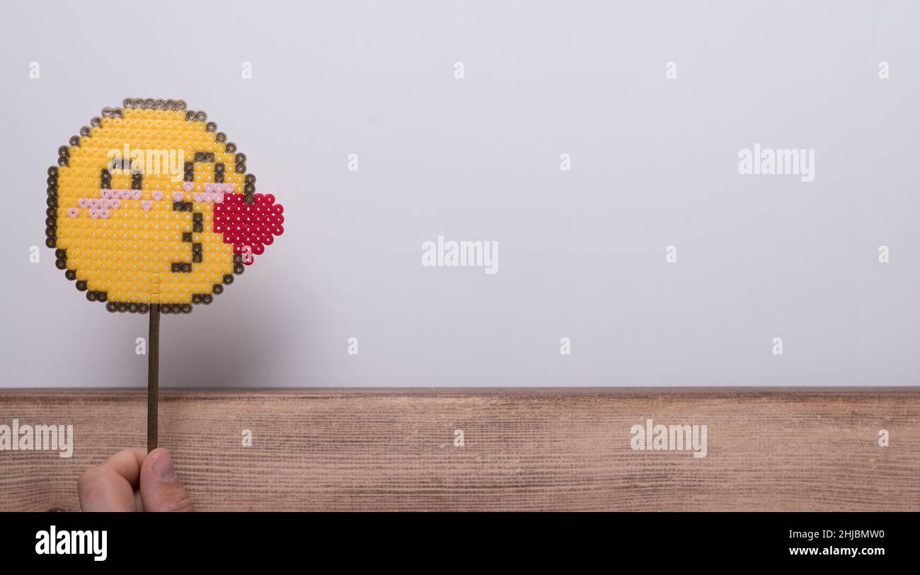 Closeup of a hand holding an emoji on a stick Stock Photo Alamy