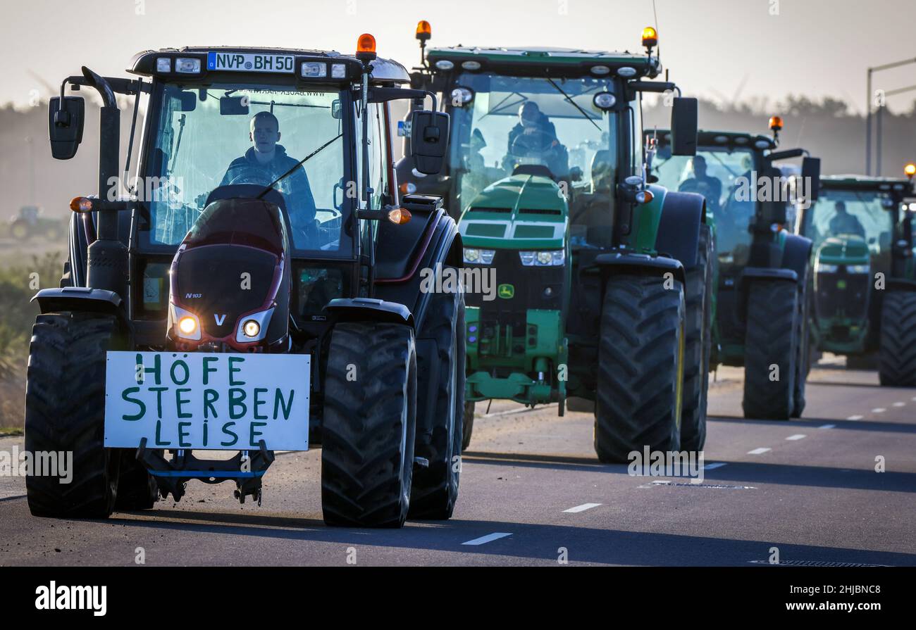 Schwerin, Germany. 28th Jan, 2022. A sign reading 'Farms die quietly' hangs from a tractor during a column drive against the new fertilizer ordinance. With the action, the farmers wanted to demonstrate against the new draft of the state fertilizer ordinance and for effective protection of groundwater. They also criticize ever new bureaucratic regulations. Credit: Jens Büttner/dpa-Zentralbild/dpa/Alamy Live News Stock Photo