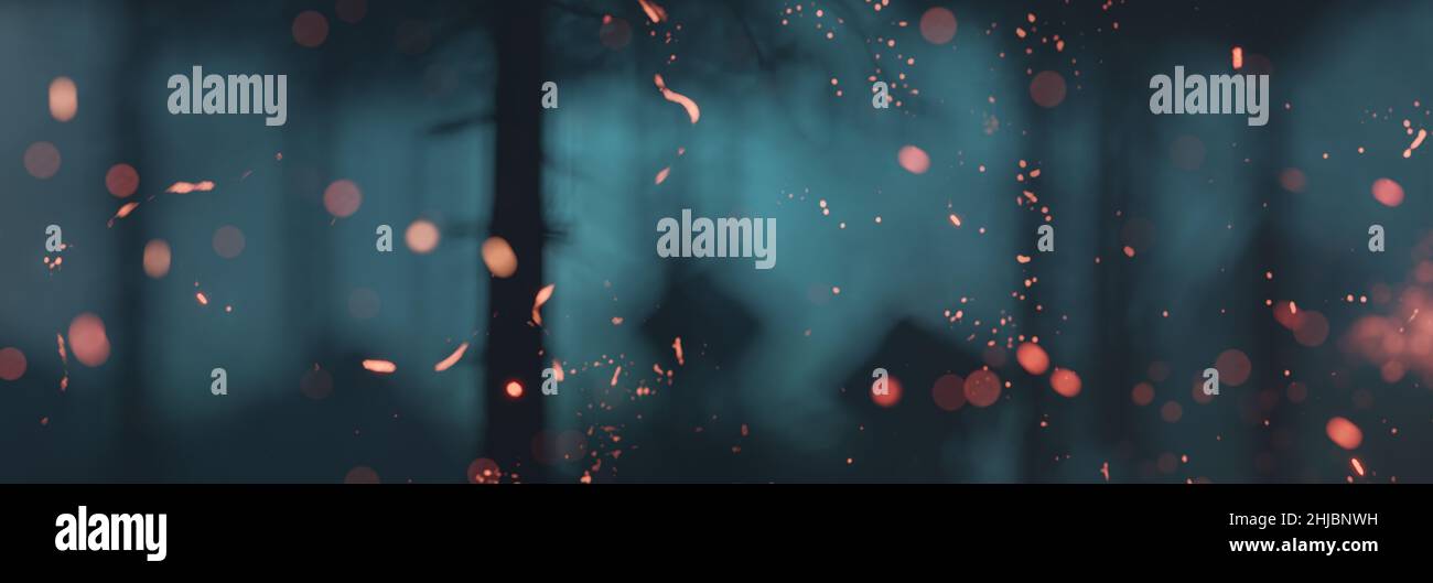 3d rendering of particles of fire in front of spooky blue forest at night Stock Photo