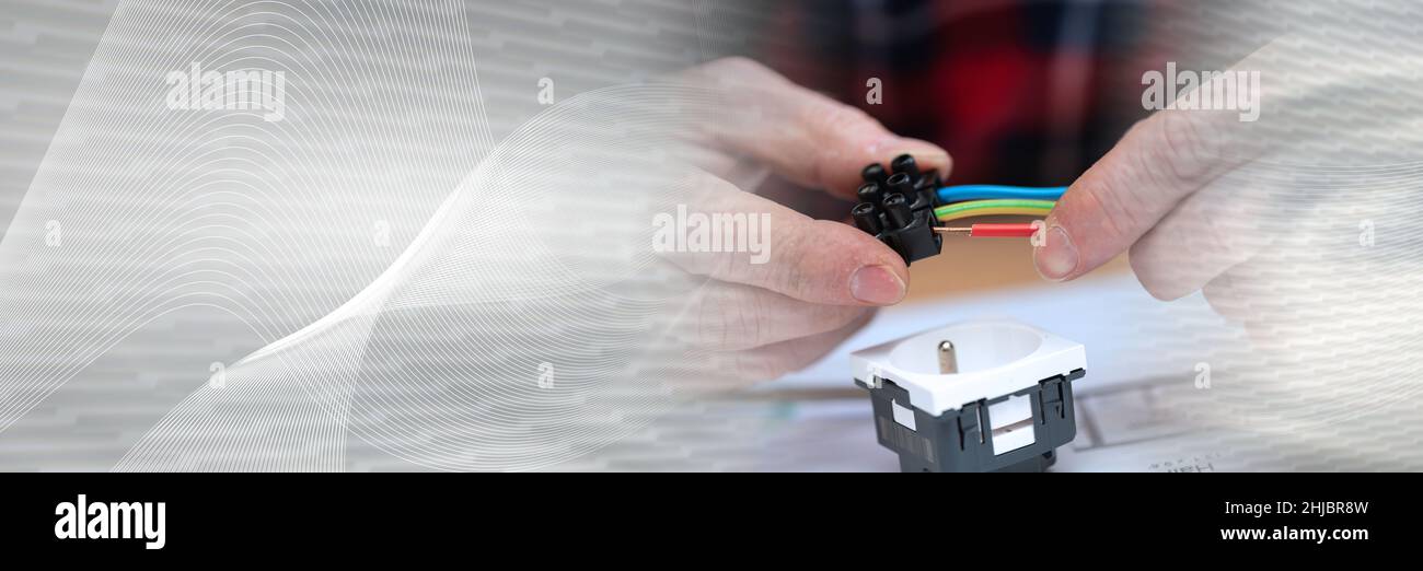 Electrician hands connecting wires in terminal block; panoramic banner Stock Photo